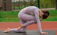 woman in white leggings and white long sleeve shirt bending her body on red and white