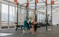 Caucasian woman stretching in a modern gym environment, promoting fitness and exercise.